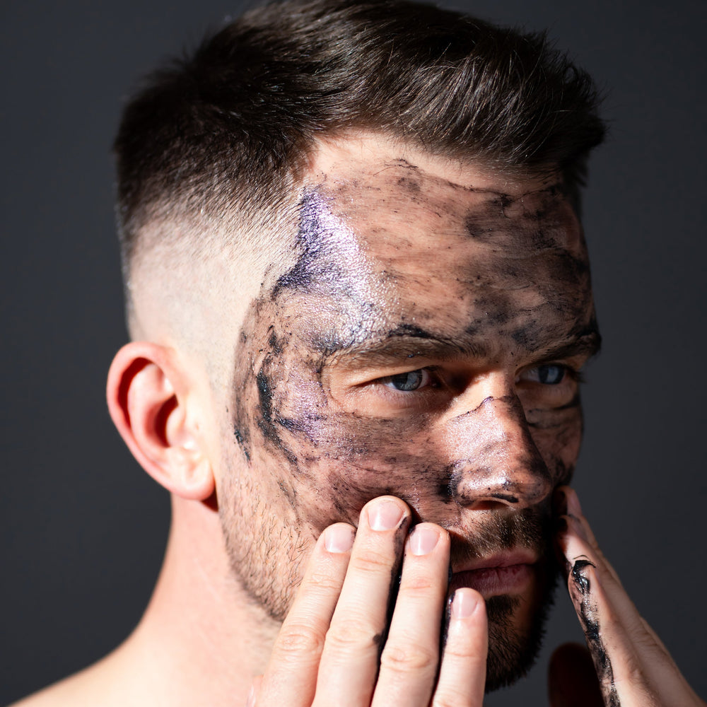 man using charcoal face scrub natural skincare